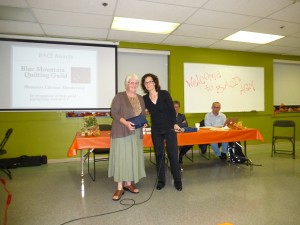 BMQG President Wendy Lynn accepts the award from BACI Co-Executive Director Tanya Sather